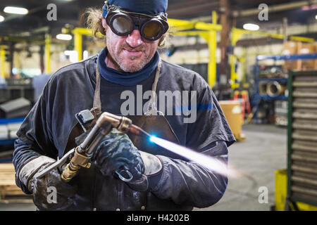 Kaukasische Schweißer Anpassung Lötlampe in Fabrik Stockfoto