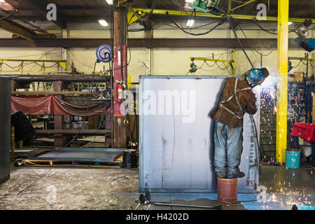 Asiatische Arbeiter Schleifen Metall-Container in Fabrik Stockfoto