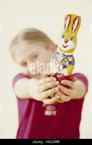 Ostern, Mädchen, Osternest, Schokolade Osterhasen zeigt Osterfest, Ostern, Osterbräuche, Osterhasen, Schokolade, Schokolade Hase, süß, Süßigkeiten, Angebote, präsent, stolz, Kindheit, fröhlich, glücklich, Natürlichkeit, innen Stockfoto