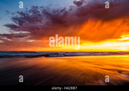 Am Strand in Del Mar, Kalifornien, spiegelt sich der malerische Sonnenuntergang am Himmel im seichten Meerwasser wider Stockfoto