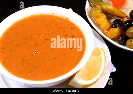 Rote Linsensuppe mit gemischten Oliven und Zitrone serviert Stockfoto