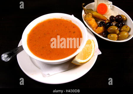 Rote Linsensuppe mit gemischten Oliven und Zitrone serviert Stockfoto