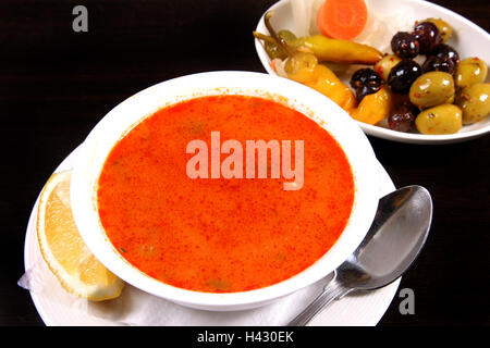 Hühnersuppe serviert mit gemischten Oliven und Zitrone Stockfoto