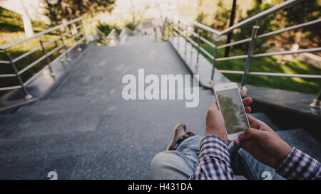 Nahaufnahme eines Mannes, die Fotos von schönen Blick mit seinem Smartphone beim Sitzen auf der Treppe Stockfoto