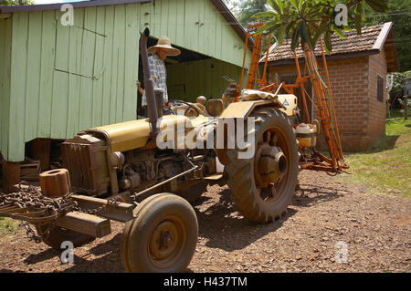 Brasilien, Rio Grande do Sul, Santa Rosa, Bauer, Traktor, stehen, Südamerika, Ziel, Kleinbauer, Landwirtschaftsmaschinen, Person, Mensch, Fazenda, Scheune, Landwirtschaft, Landwirtschaft, Gaucholand, Soja-Anbau, Landwirt, Kolonie, Bauernhof, im Außenbereich Stockfoto