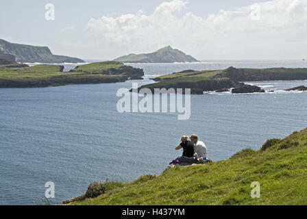 Irland, Kerry, Munster, Iveragh-Halbinsel, Valencia Island, Felsen, Klippe Küste, Touristen, sitzen, zurück, Ansicht, Person, Küstenlandschaft, Landschaft, Klippen, Küste, Küste, Ansicht, Meer, paar, Zweisamkeit, sonnig, Stockfoto