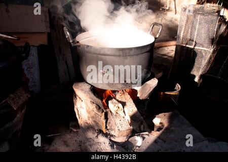 Alten Topf Essen kochen auf Holzfeuer Ofen brennen Stockfoto