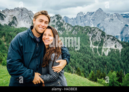 Kaukasische paar umarmt ordentlich Bergkette, Tarvisio, Wien, Österreich Stockfoto