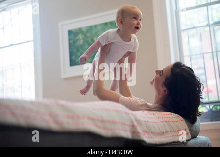 Weißen Mutter sitzt auf einem Sofa heben baby Sohn Stockfoto