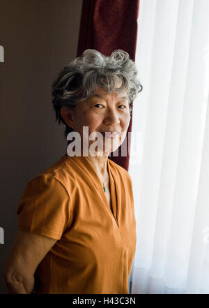 Japanische Frau am Fenster stand lächelnd Stockfoto