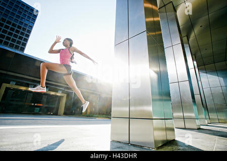 Schwarze Frau laufen und springen auf Stadt Bürgersteig Stockfoto