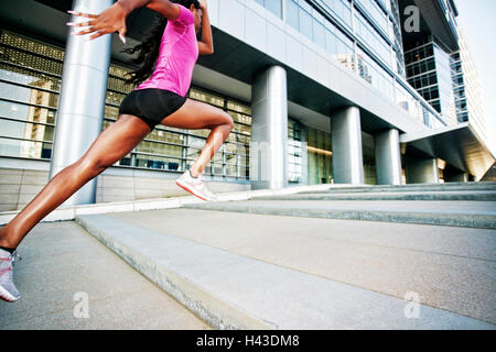 Schwarze Frau laufen und springen auf Stadt-Treppe Stockfoto