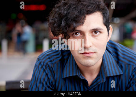 Ernster Hispanic Mann mit lockigem Haar Stockfoto