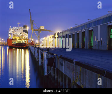 Frachtschiff unter Kran im Hafen bei Nacht Stockfoto