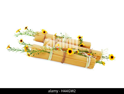 Italienische Spaghetti ungekocht dekoriert mit gelben Blüten, die isoliert auf weißem Hintergrund. Stockfoto