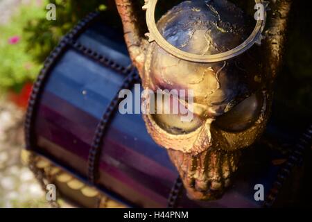 Stahlskulptur von Schädel Bewachung Treasure chest Stockfoto