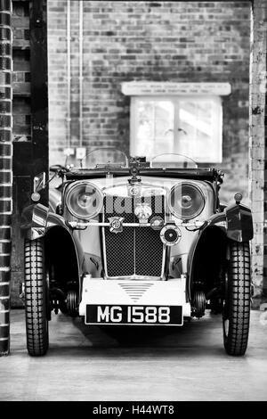 1932 MG Auto in einer Werkstatt in Bicester Heritage Centre. Oxfordshire, England. Schwarz / weiß Stockfoto