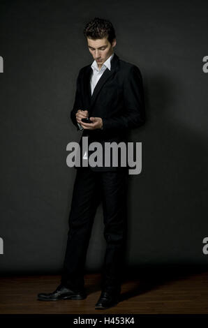 Mann, jung, Messestand, anzeigen, "BlackBerry", Konzentration, Porträt, Person, Geschäftsmann, Ansicht, ernst, PIM, e-mail, schreiben, empfangen, Daten, Tastatur, Dateneingabe, Kommunikation, Kleidung, Anzug, schwarz, Shirt, weiß, dunkelhaarige, Geschäft, Studio, Stockfoto