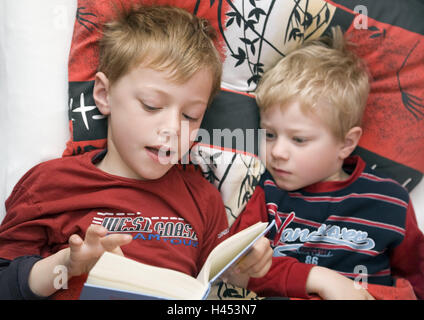 Jungs, zwei, Bett, liegen, lesen, Buch, Porträt, Person, Kinder, Kindheit, Kind, Geschwister, Brüder, Aufmerksamkeit, Geschichte, Kinder-und Jugendbuch, aufregend, gemeinsam, Märchen, hören, hören, behaglich, Stockfoto