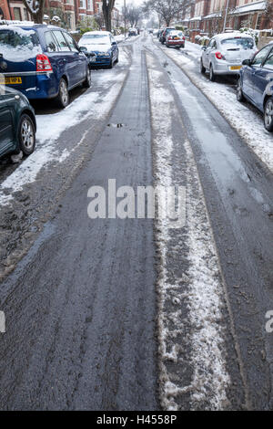 Auf rutschiger Fahrbahn. Schneematsch in einer Wohnstraße im Winter, Nottinghamshire, England, Großbritannien Stockfoto