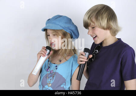 Mädchen, junge, Karaoke, Person, Geschwister, Kinder, Mikrofone, singen, Spaß, Kind Karaoke, Musik, Bewegung, Konzentration, Spaß, Kappe, Kopfbedeckung, Türkis, Halskette, Sonnenbrille, Stockfoto