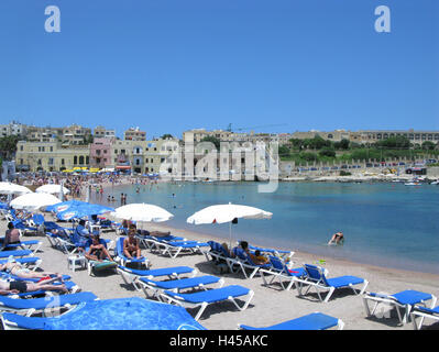 Malta, St. Julians, St. George's Bay, Blick auf den Strand, Insel, Insel im Mittelmeer, Reiseziel, Blick auf die Stadt, Tourismus, Meer, Wasser, das Mittelmeer, Sandstrand, Liegestühle, Strand liegen, Sonnenschirme, Menschen, Touristen, Badegäste, Urlaub, Urlauber, Strandurlaub, Stockfoto