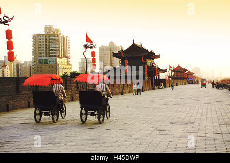 China, Shaanxi, Xian, Stadtmauer, Passanten, Rikschas, Abendlicht, Stockfoto