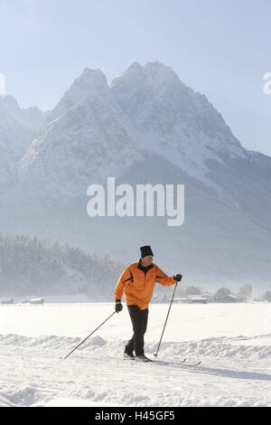 Senior, Langlauf, Wintersport, Berglandschaft, Zugspitze, Garmisch-Partenkirchen, Bayern, Deutschland, Menschen, sport, sportlich, aktiv, Fit, Fitness, Langlaufen, Skilangläufer, Langlaufloipe, Landschaft, Berge, Zugspitze-Massivs, Waxenstein, winter Sport Ort, Ski-Ort, Winter, Neuschnee, Bewegung, Aktivität, motiviert, aktiv, Herz-Kreislauf, Gesundheit, gesunde, ältere Bürger, alte Person, Werdenfels, Oberbayern, Stockfoto