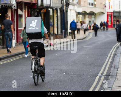 Deliveroo Radfahrer aus dem beliebter heiße Nahrung und Fast Food Lieferung Unternehmen Fahrrad durch die Straßen der Stadt. Stockfoto