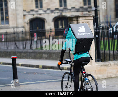 Deliveroo Radfahrer aus dem beliebter heiße Nahrung und Fast Food Lieferung Unternehmen Fahrrad durch die Straßen der Stadt. Stockfoto