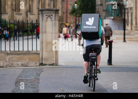 Deliveroo Radfahrer aus dem beliebter heiße Nahrung und Fast Food Lieferung Unternehmen Fahrrad durch die Straßen der Stadt. Stockfoto