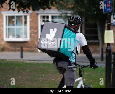 Deliveroo Radfahrer aus dem beliebter heiße Nahrung und Fast Food Lieferung Unternehmen Fahrrad durch die Straßen der Stadt. Stockfoto