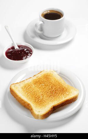 Toastbrot mit Himbeermarmelade und Kaffeetasse auf weißem Hintergrund Stockfoto