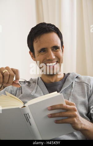 Mann, lachen, Buch, lesen, Brille, Erholung, nehmen Sie es einfach, schalten Sie Rest, Hobby, Stressabbau, Erholung, Freizeit, Aktivität, Interesse, Konzentration, glücklich, home, Person, glücklich, sitzen, Porträt, Konzentration, Literatur, innen, Stockfoto
