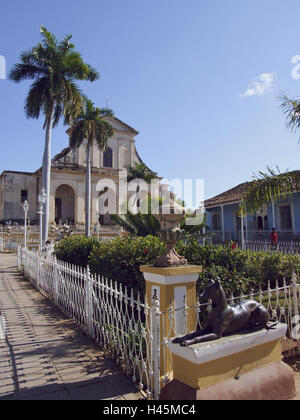 Plaza Mayor, Kirche, Iglesia Parroquial de la Santisima Trinidad, Trinidad, Kuba, Urlaubsziel, Destination, die Karibik, Tourismus, Urlaub, Blick auf die Stadt, Stadtzentrum, Orte, Interesse, Architektur, Gebäude, Strukturen, historisch, Kirche, Turm, Iglesia de la Santísima Trinidad, Zaun, Park, Skulptur, Hund Skulptur, Palmen, Menschen, Passanten, UNESCO-Weltkulturerbe, Stockfoto