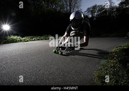 Down711, Longboarder, Helm, Dämmerung, Straße, Kurve, Abfahrt, Longboard, Skateboard, Streetskate, Sport, Longboarden, Trend-Sport, Geschwindigkeit, Gefahr, Risiko, Adrenalin, Longboard Rennen, Leute, Mann, Skateboarder, Schutzhelm, Schutz, Licht, Blendung, Schatten, Stockfoto