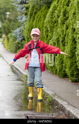 Ein Junge, 5 Jahre alt, mit Regenschutz, Exterieur, Stockfoto