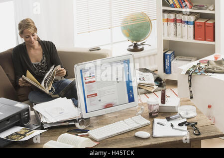 Frau, jung, Sofa, sitzend, Verwalter, Schallplatten, Schreibtisch, schauen Sie bei Computern, Druckern Bildschirm kein Eigentum Release-Serie, Menschen, 20-30 Jahre, Student, Tisch, Flachbildfernseher, Tastatur, Maus, Computer, Apple Mac, Mini, Buch, Notizblock, geöffneten Pen Arbeit Papiere Arbeit Stockfoto