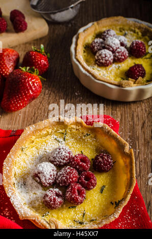 Zitronentorte mit Rosmarin und Beeren, gefüllt mit Sahne garniert Beeren Stockfoto