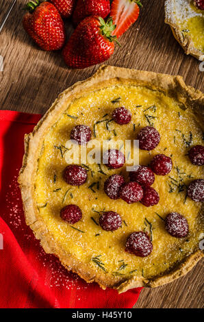 Zitronentorte mit Rosmarin und Beeren, gefüllt mit Sahne garniert Beeren Stockfoto