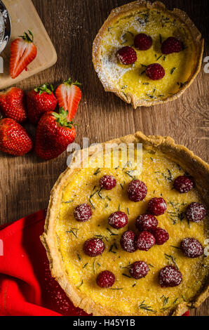 Zitronentorte mit Rosmarin und Beeren, gefüllt mit Sahne garniert Beeren Stockfoto