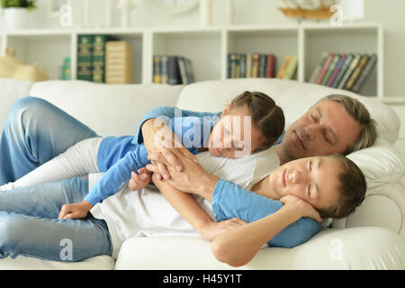 Schlafende Bruder, Schwester und Vater im Zimmer Stockfoto