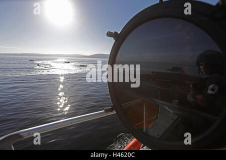 Sperrfrist bis 1900 Donnerstag Oktober 13 A Rating manning eine allgemeine Zweck Maschinengewehr (KPMG) spiegelt sich in einer Signallampe an Bord der HMS GWR - Royal Navy Hunt-Klasse Mine Gegenmaßnahmen Schiff - in den Seen von westlichen Schottland, während einer mehrere Boot-Attacke Übung simuliert einen Angriff von FIAC (schnell Inshore Angriff Craft), als Teil eines Royal Navy Joint Warrior Trainingsübung. Stockfoto