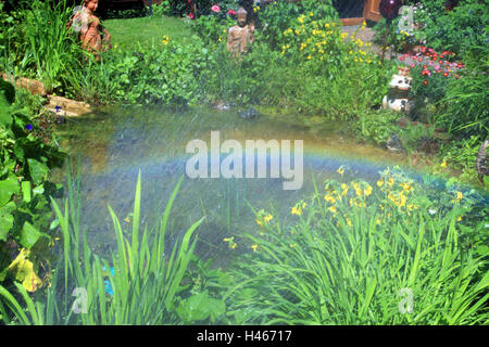 Regenbogen über Gartenteich Stockfoto