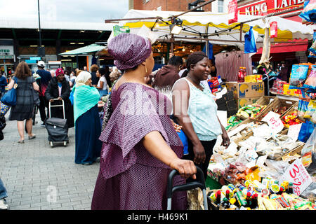 Hackney. Ridley Straße Markt. Frauen-Shop im Gemüse- und Stall. Stockfoto