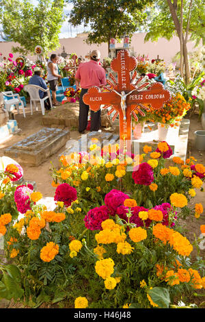 Menschen knüpfen zwischen Gräbern, verziert mit aufwendigen floralen Pedal Wandteppiche zu Ehren des Verstorbenen auf dem Friedhof San Antonino Castillo im Laufe des Tages von den Dead Festival bekannt als D'a de Muertos am 3. November 2013 in San Antonino Castillo Velasco, Oaxaca, Mexiko. Stockfoto