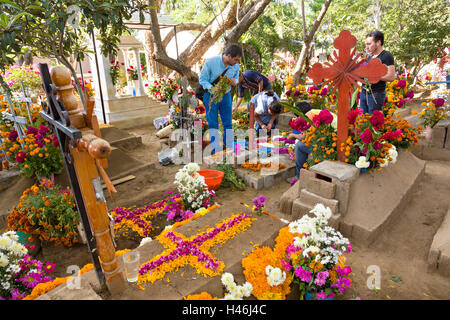 Menschen dekoriert ein Graves mit aufwendigen floralen Pedal Wandteppiche zu Ehren des Verstorbenen auf dem Friedhof San Antonino Castillo im Laufe des Tages von den Dead Festival bekannt als D'a de Muertos am 3. November 2013 in San Antonino Castillo Velasco, Oaxaca, Mexiko. Stockfoto