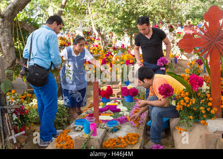 Menschen dekoriert ein Graves mit aufwendigen floralen Pedal Wandteppiche zu Ehren des Verstorbenen auf dem Friedhof San Antonino Castillo im Laufe des Tages von den Dead Festival bekannt als D'a de Muertos am 3. November 2013 in San Antonino Castillo Velasco, Oaxaca, Mexiko. Stockfoto