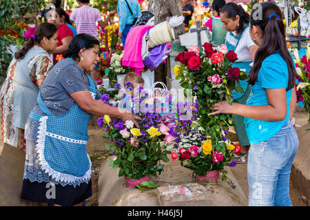 Menschen dekoriert ein Graves mit aufwendigen floralen Pedal Wandteppiche zu Ehren des Verstorbenen auf dem Friedhof San Antonino Castillo im Laufe des Tages von den Dead Festival bekannt als D'a de Muertos am 3. November 2013 in San Antonino Castillo Velasco, Oaxaca, Mexiko. Stockfoto