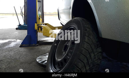 Sommer mit Winterreifen in einen Autoservice vor schlechtem Wetter Saison ändern Stockfoto